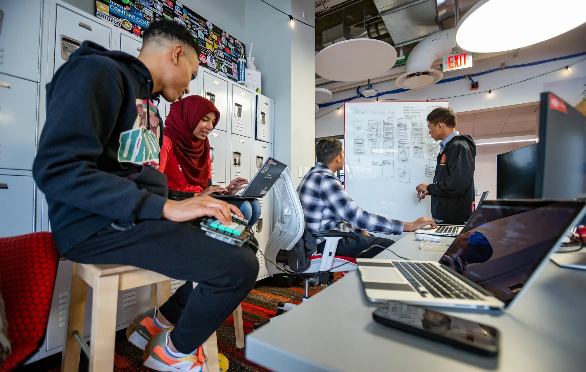 students at laptops and whiteboard