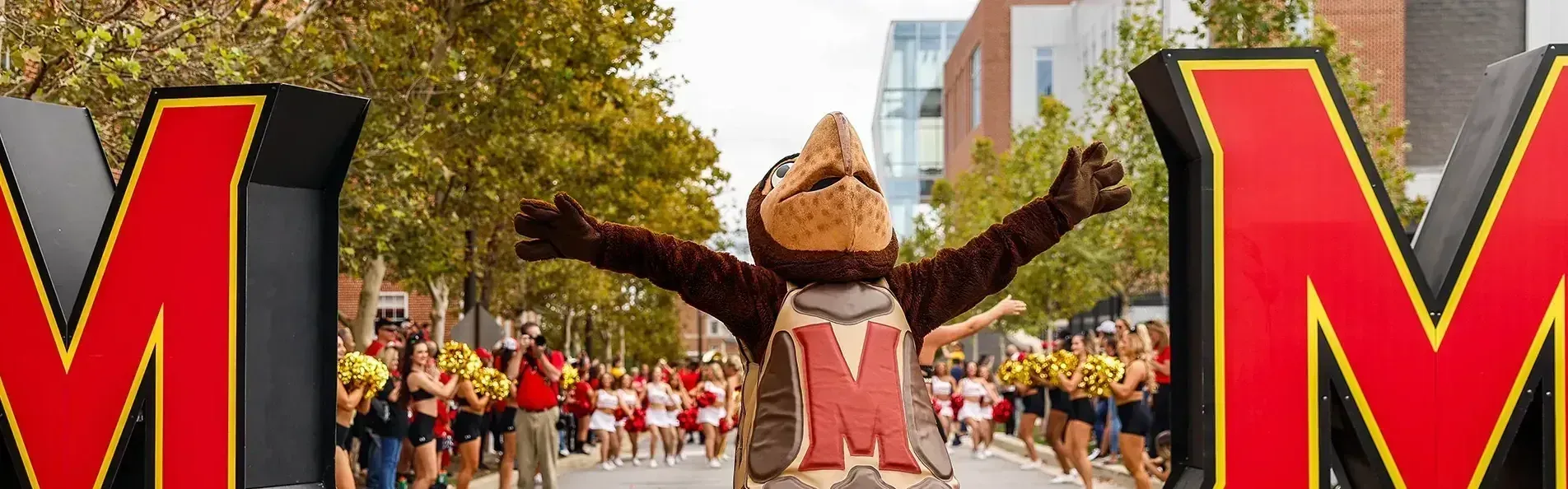 Testudo celebrates and the football team arrives at Terp Alley.