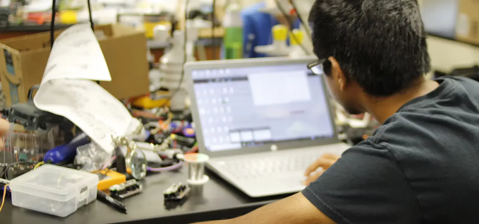 Student in a lab looking at a laptop