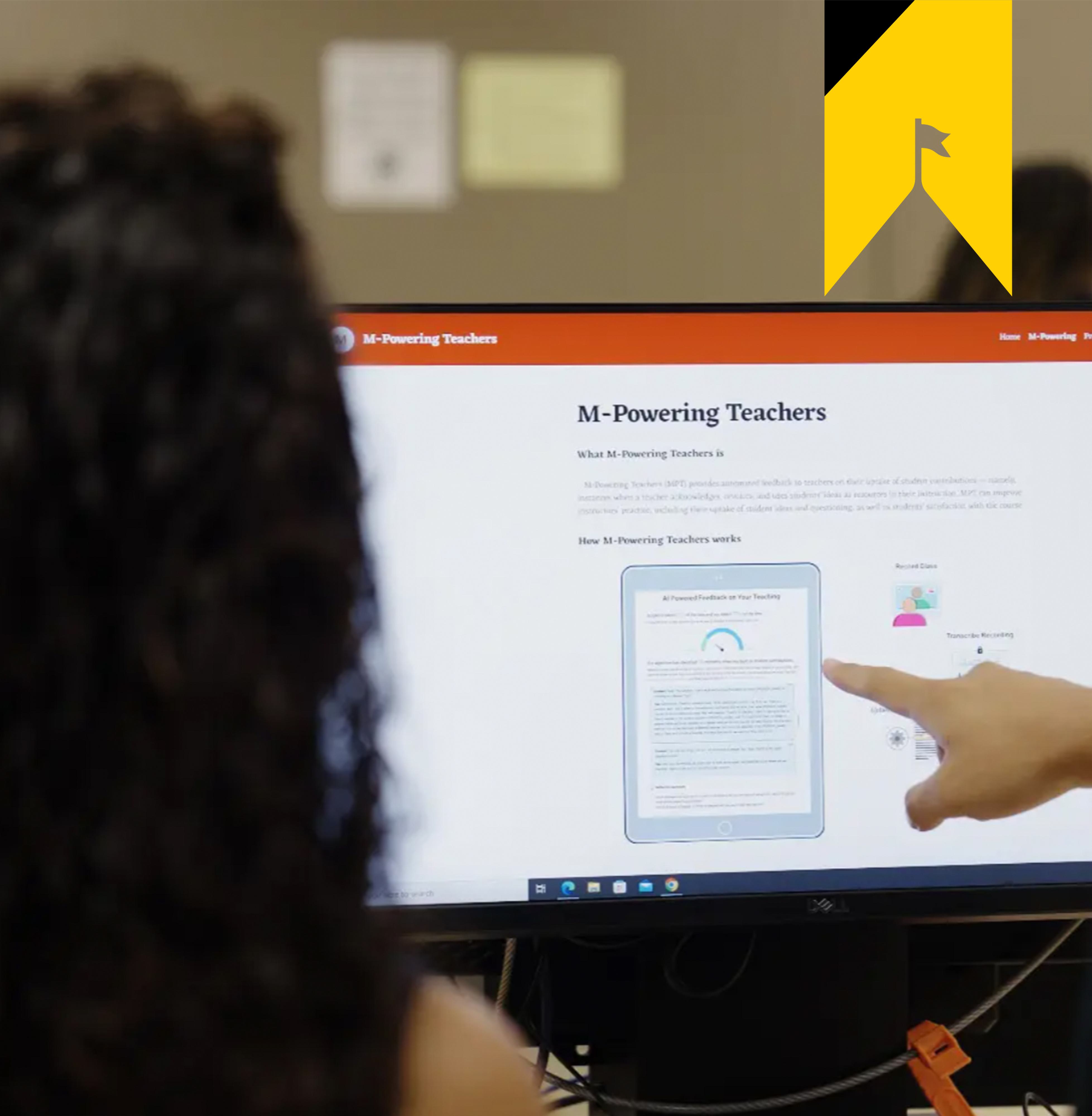 Two people view the MPowering Teachers website on a desktop