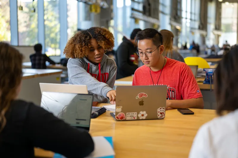 Students work together over a laptop