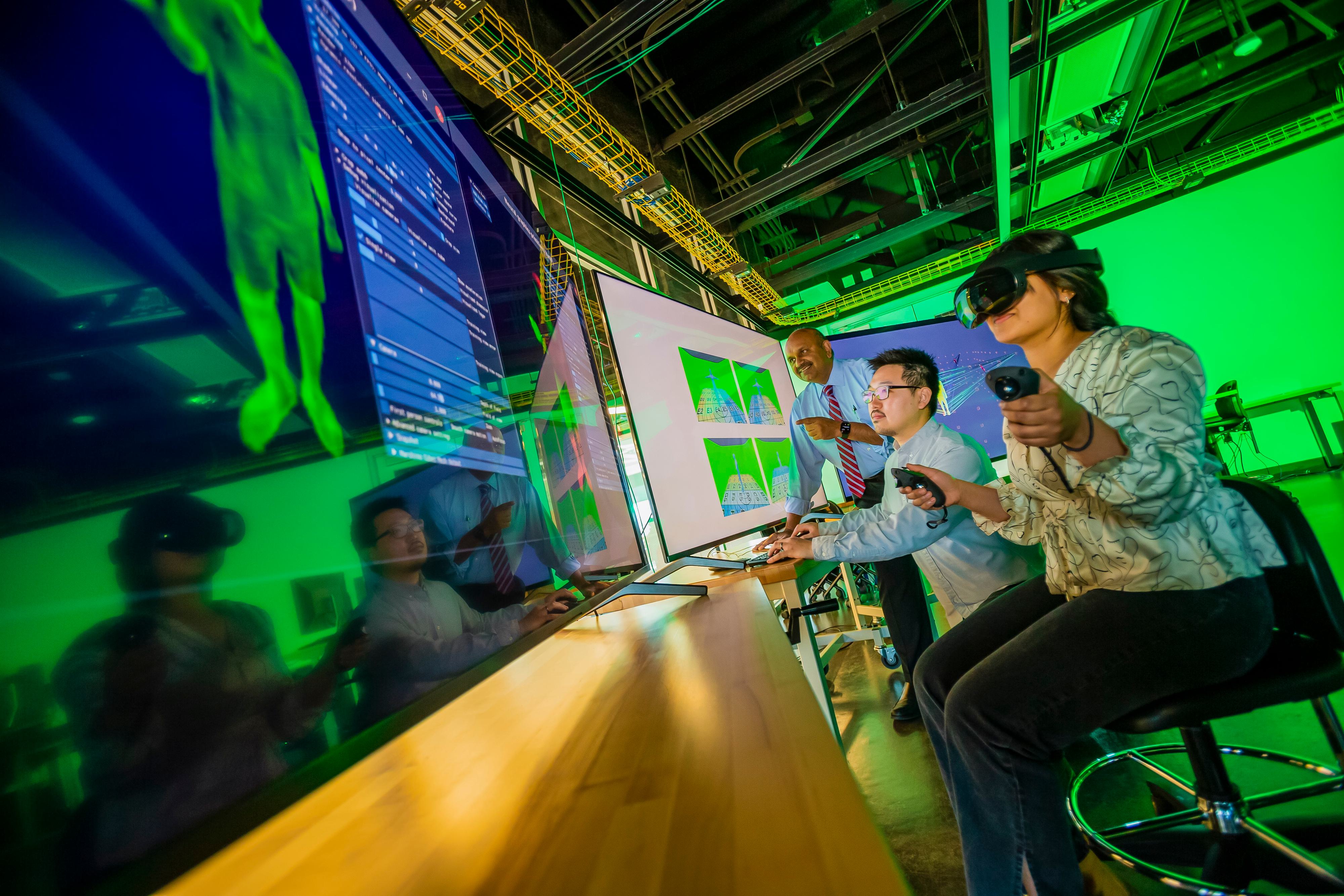 "Professor Amitabh Varshney, dean of the College of Computer, Mathematical and Natural Sciences (left), UMIACS, AR/VR researcher Sida Li (center) and computer science major Khushi Bhansali (right) working in the Maryland Blended Reality Center inside Iribe."