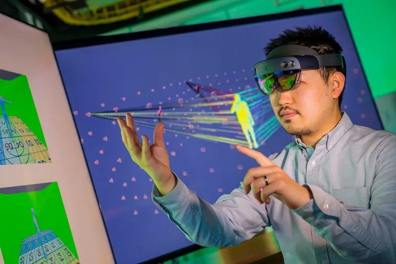 Student uses a pair of smart glasses to interact with an object in augmented reality