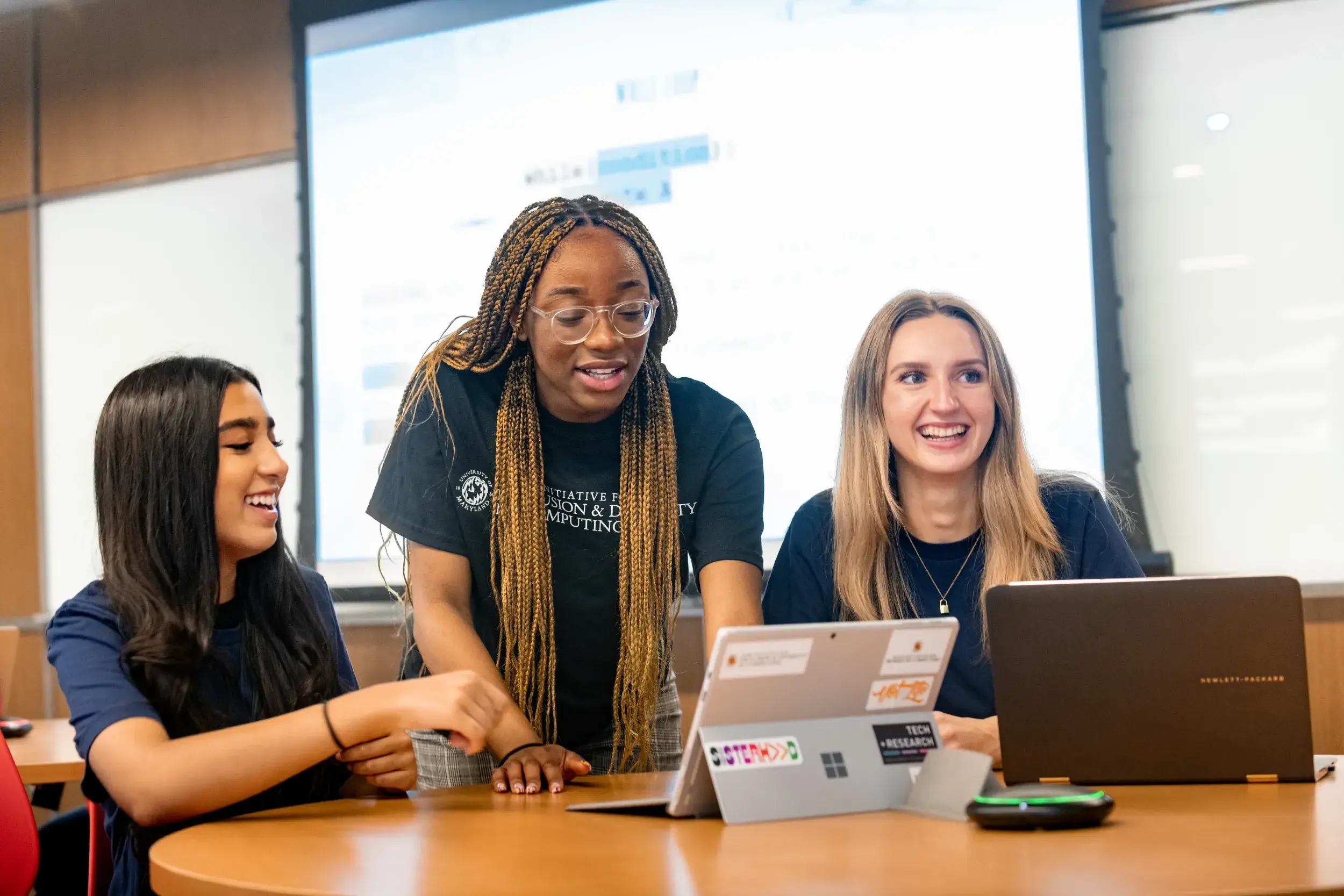 A UMD student works with high school students a computing camp