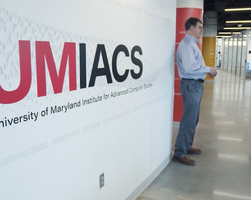 Man leaning against wall with UMIACS